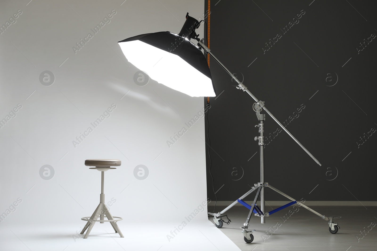 Photo of White photo background, stool and professional lighting equipment in modern studio