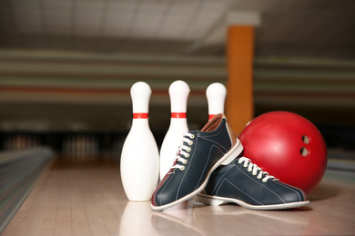 Photo of Shoes, pins and ball on bowling lane in club