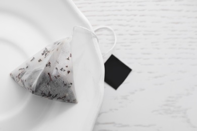 Photo of Pyramid tea bag on white table, top view. Space for text