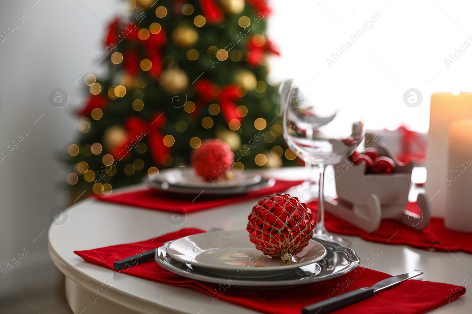 Photo of Festive table setting and Christmas tree in stylish room interior