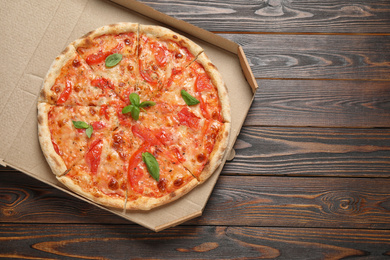 Delicious pizza Margherita on wooden table, top view. Space for text