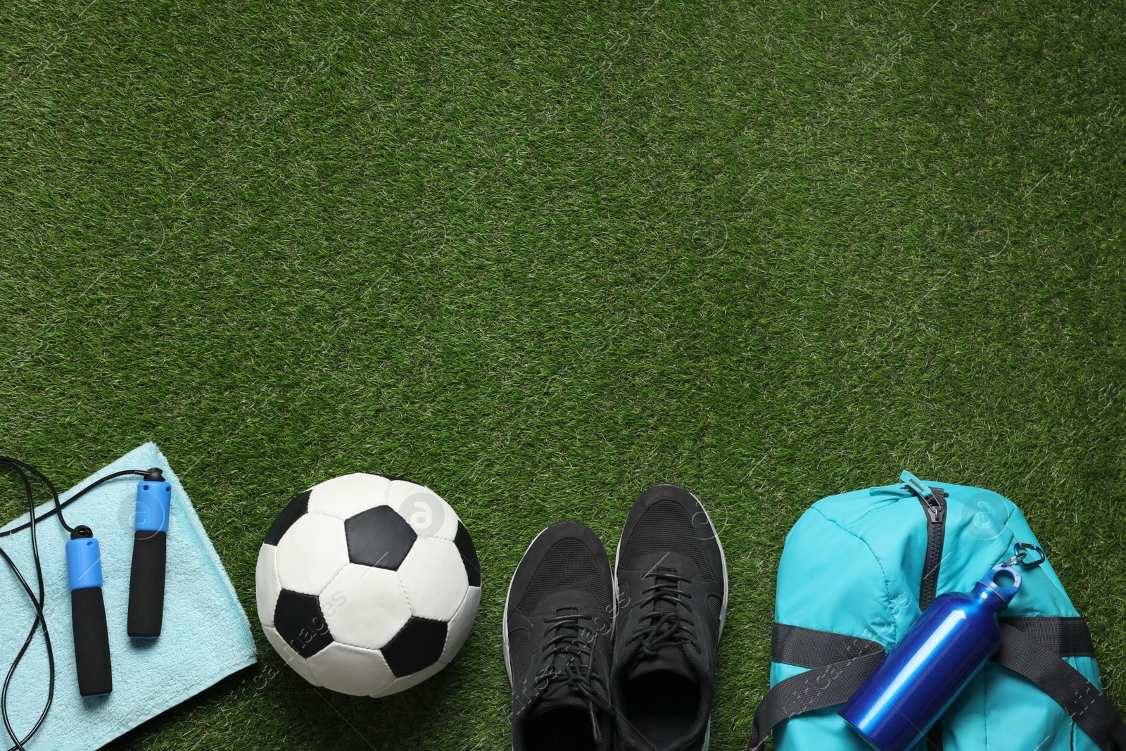 Photo of Flat lay composition with sports equipment on green grass, space for text