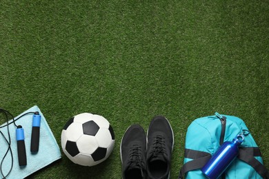 Photo of Flat lay composition with sports equipment on green grass, space for text