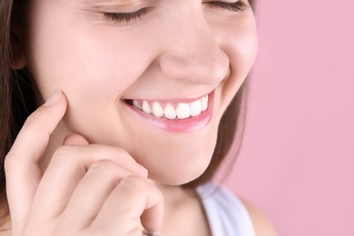 Young woman with beautiful smile on color background, closeup. Space for text