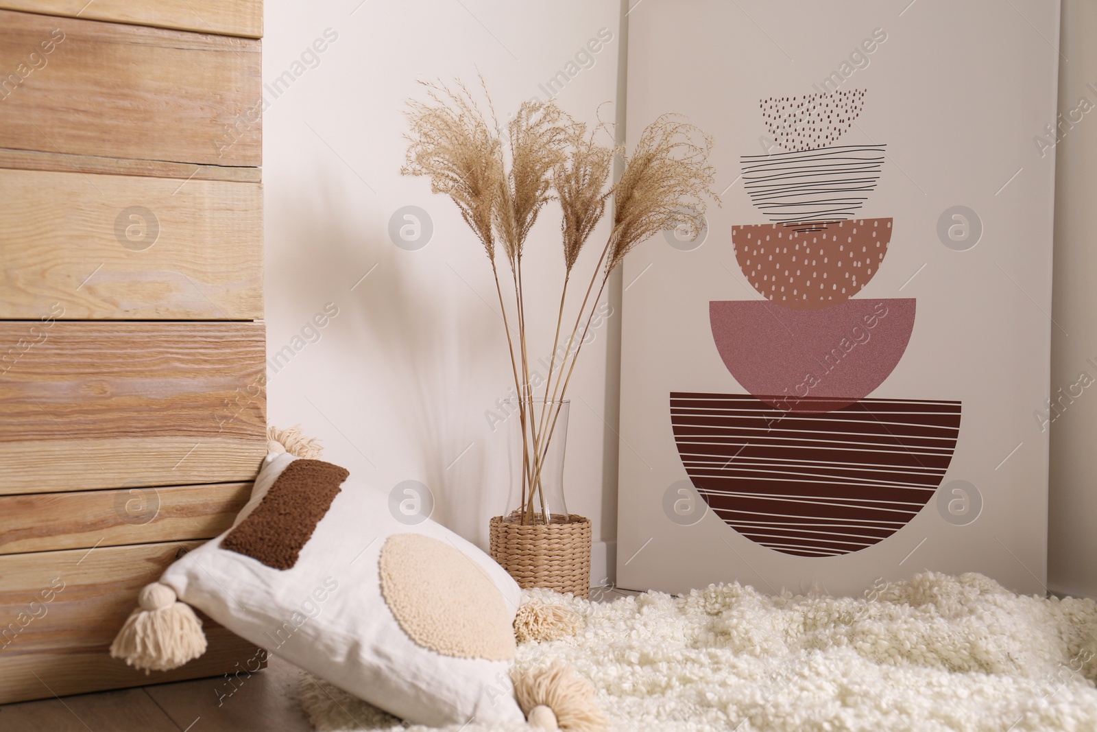 Photo of Vase with decorative dried plants and painting in stylish room interior