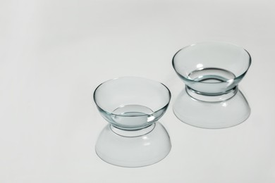 Photo of Pair of contact lenses on white reflective surface