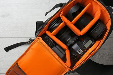 Photo of Bag with digital camera on floor. Professional photographer's equipment