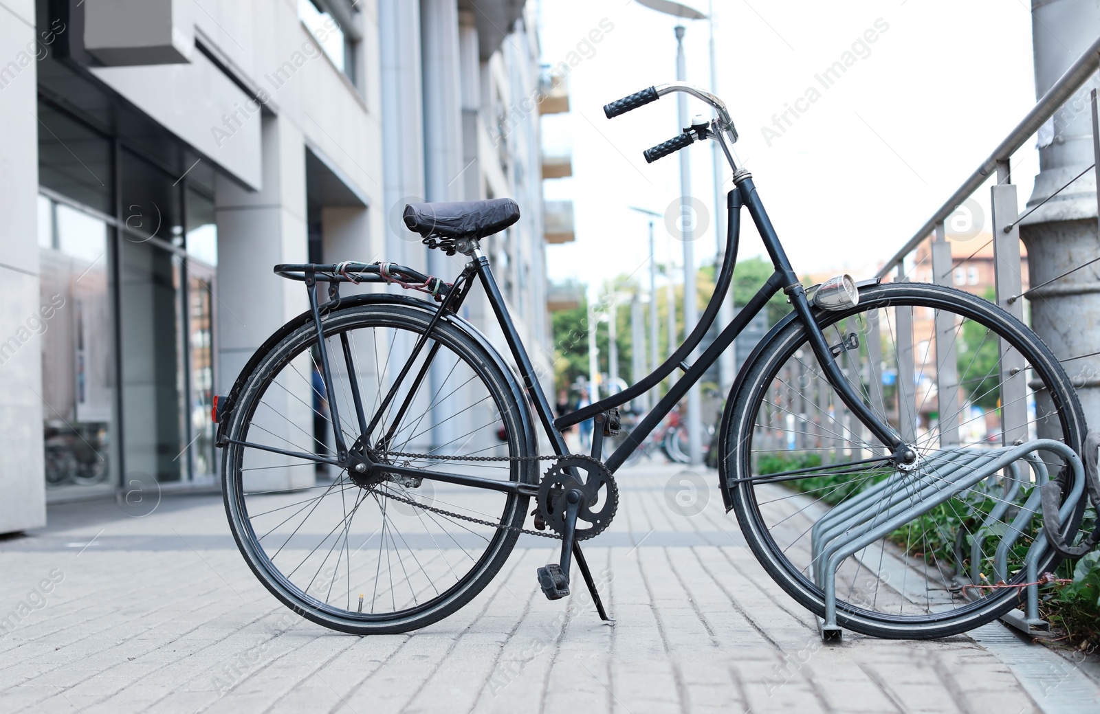 Photo of Modern black bicycle parked on city street