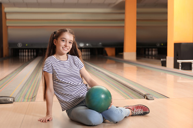 Photo of Preteen girl with ball in bowling club
