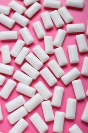 Photo of Tasty white chewing gums on pink background, flat lay
