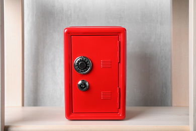 Photo of Red steel safe with mechanical combination lock on shelf