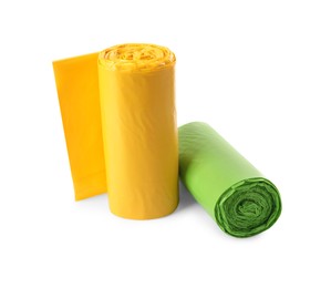 Photo of Rolls of green and yellow garbage bags on white background