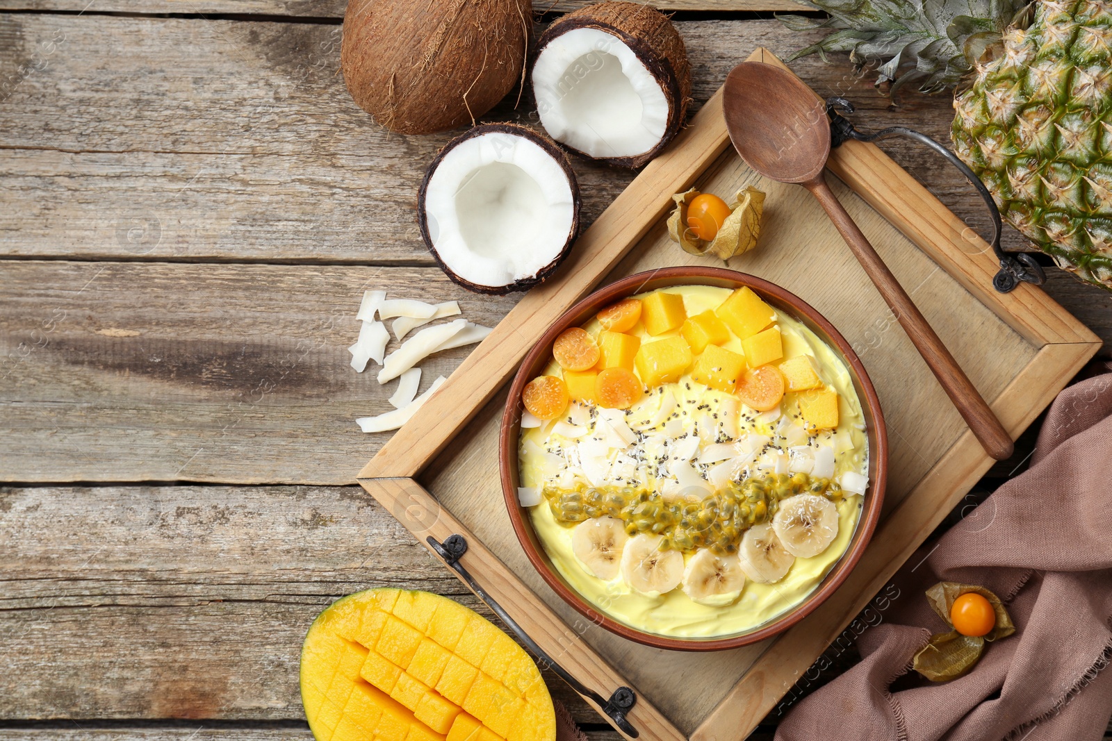 Photo of Tasty smoothie bowl with fresh fruits served on wooden table, flat lay. Space for text