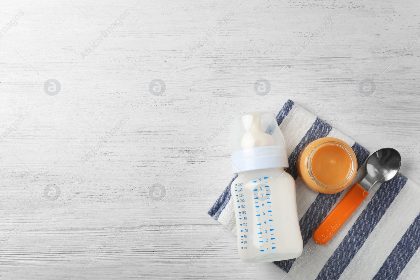 Photo of Flat lay composition with baby food and space for text on wooden background