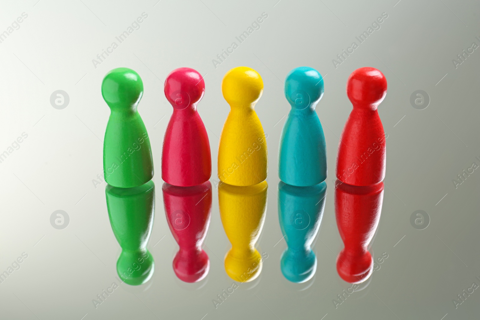 Photo of Colorful pawns on white background. Social inclusion concept