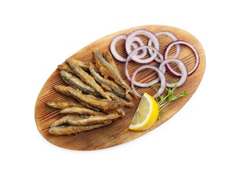 Photo of Wooden board with delicious fried anchovies, lemon, and onion rings on white background, top view
