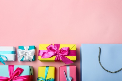 Flat lay composition with shopping bag and gifts on color background