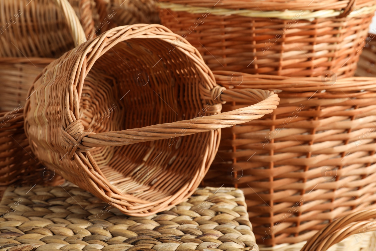 Photo of Many different wicker baskets made of natural material as background, closeup