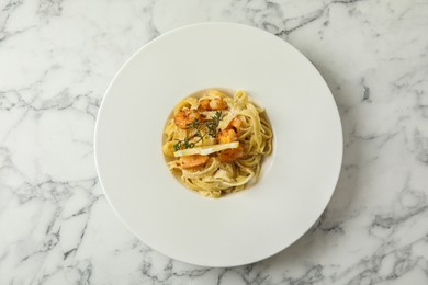 Delicious pasta with shrimps on white marble table, top view