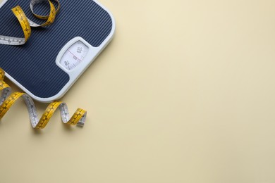 Scales and measuring tape on beige background, flat lay. Space for text