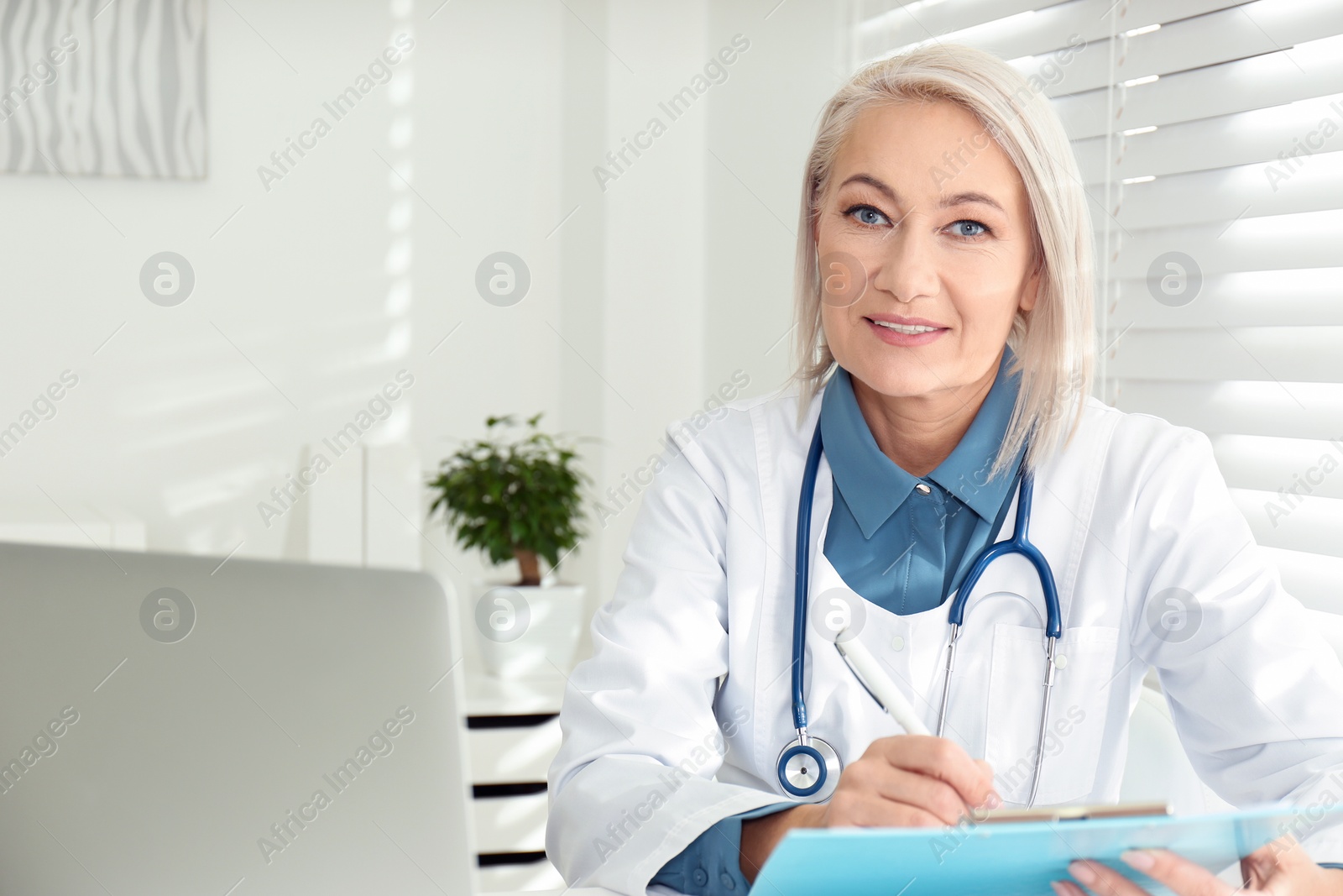 Photo of Portrait of mature female doctor in white coat at workplace