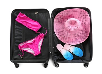 Suitcase with bikini, hat and slippers on white background, top view