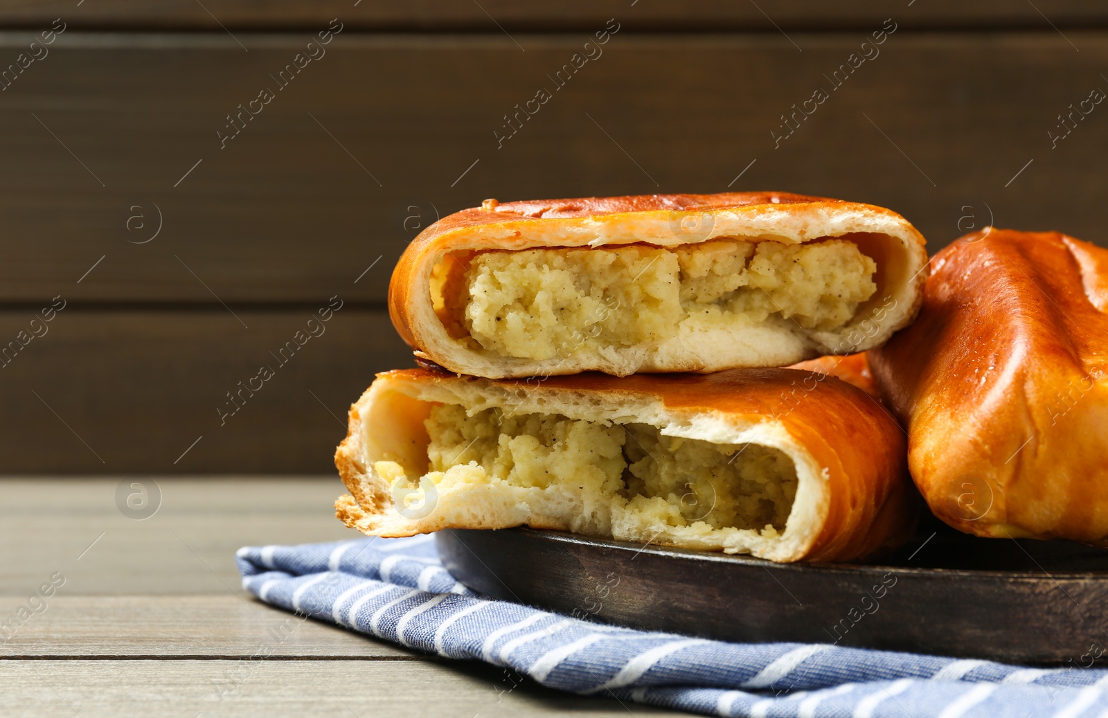 Photo of Delicious baked patties with potato on wooden table, space for text