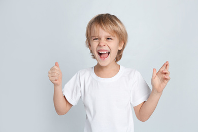 Photo of Happy little boy on light grey background