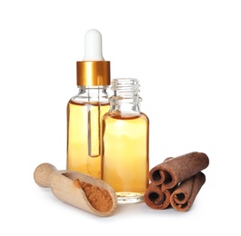 Photo of Bottles of essential oils, cinnamon sticks and powder on white background