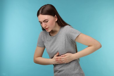 Photo of Woman having heart attack on light blue background