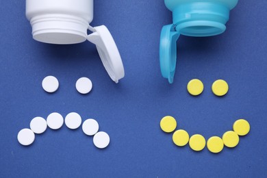 Photo of Happy, sad faces made of antidepressant pills and bottles on dark blue background, flat lay