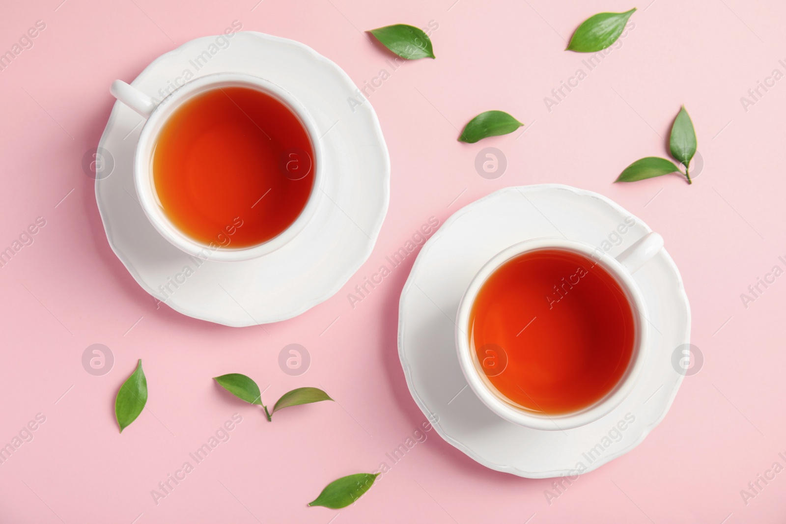 Photo of Flat lay composition with delicious tea and green leaves on color background