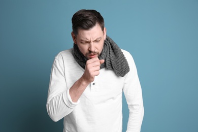 Mature man coughing on color background