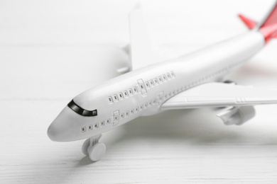 Photo of Toy airplane on white wooden background, closeup