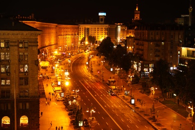 Photo of KYIV, UKRAINE - MAY 22, 2019: Beautiful view of illuminated Khreshchatyk street with buildings and road traffic