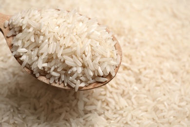 Photo of Long grain rice in wooden spoon, closeup view