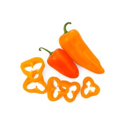 Photo of Cut and whole orange hot chili peppers isolated on white, top view