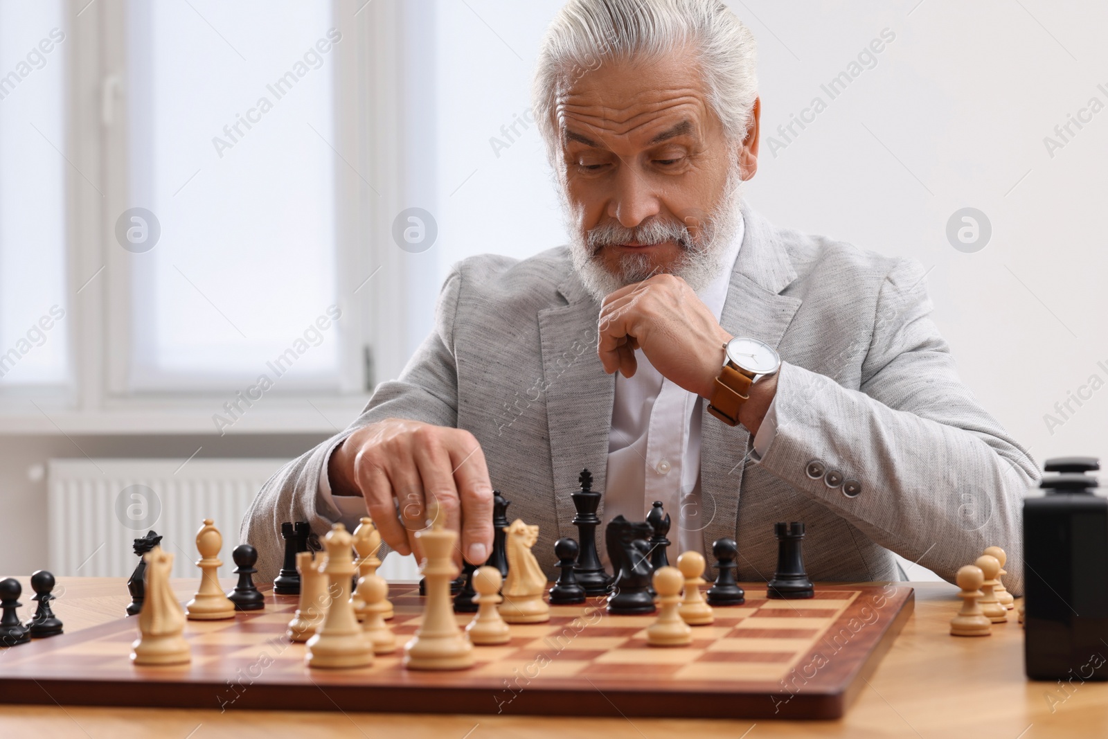 Photo of Man playing chess during tournament at table indoors