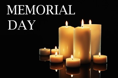 Image of Memorial day. Wax candles burning on black background