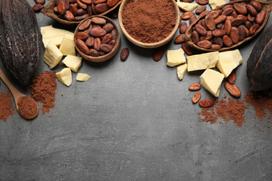 Flat lay composition with organic cocoa butter on grey table. Space for text