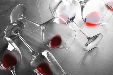 Photo of Different glasses with red wine on grey background
