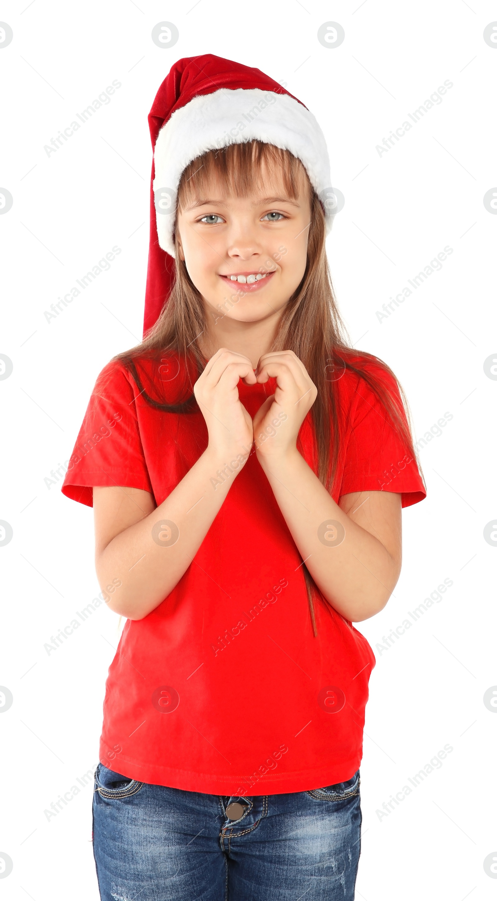 Photo of Cute little child in Santa hat putting hands in shape of heart on white background. Christmas celebration