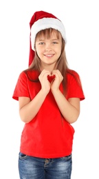 Cute little child in Santa hat putting hands in shape of heart on white background. Christmas celebration