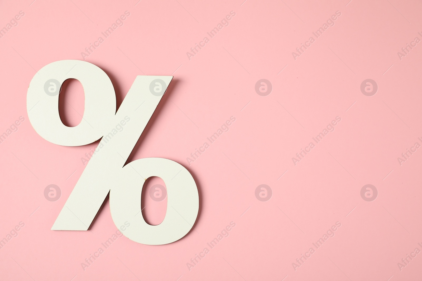 Photo of White percent sign on pink background, top view. Space for text