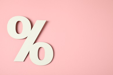 Photo of White percent sign on pink background, top view. Space for text