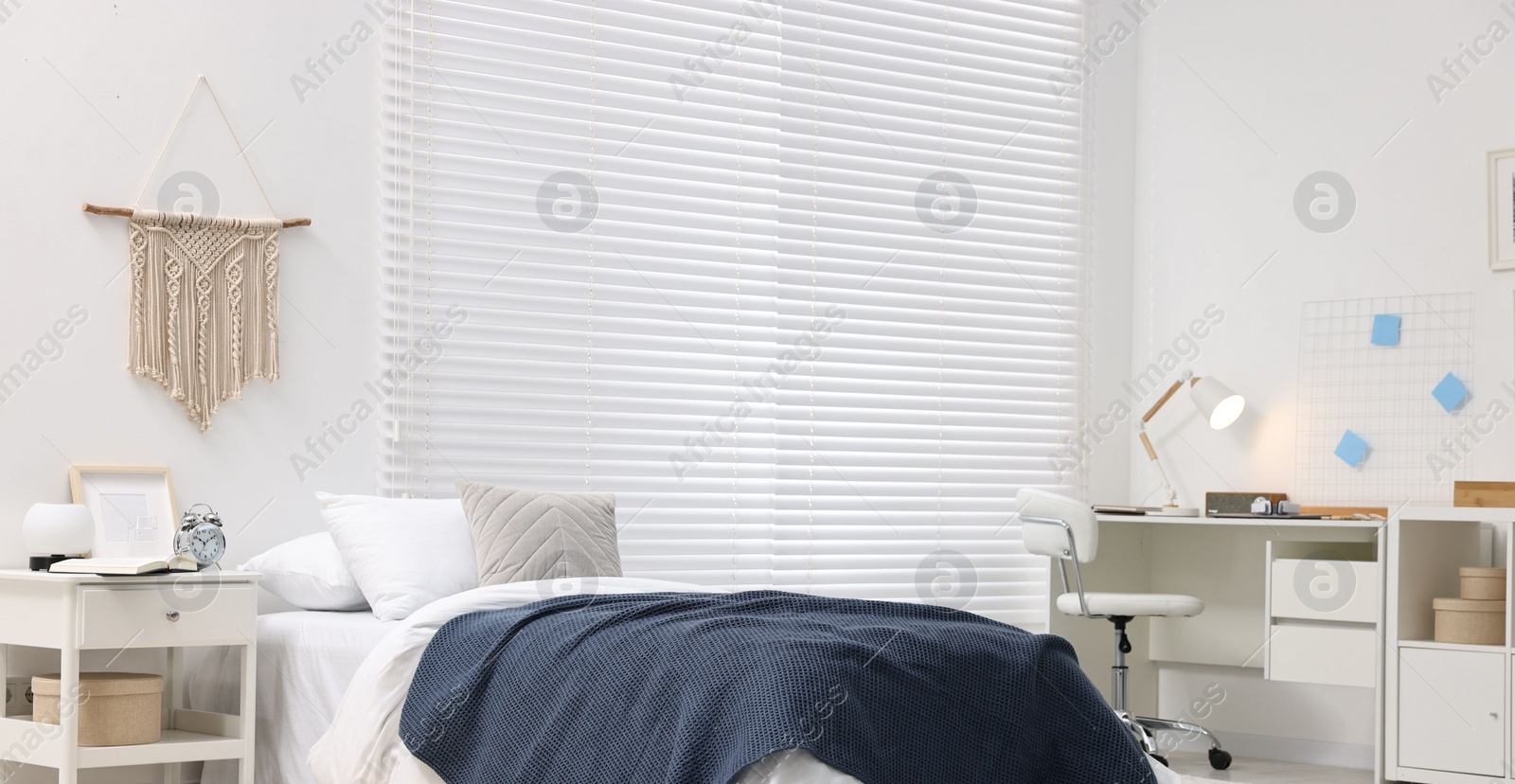 Photo of Bedroom interior with comfortable furniture, big window and white blinds