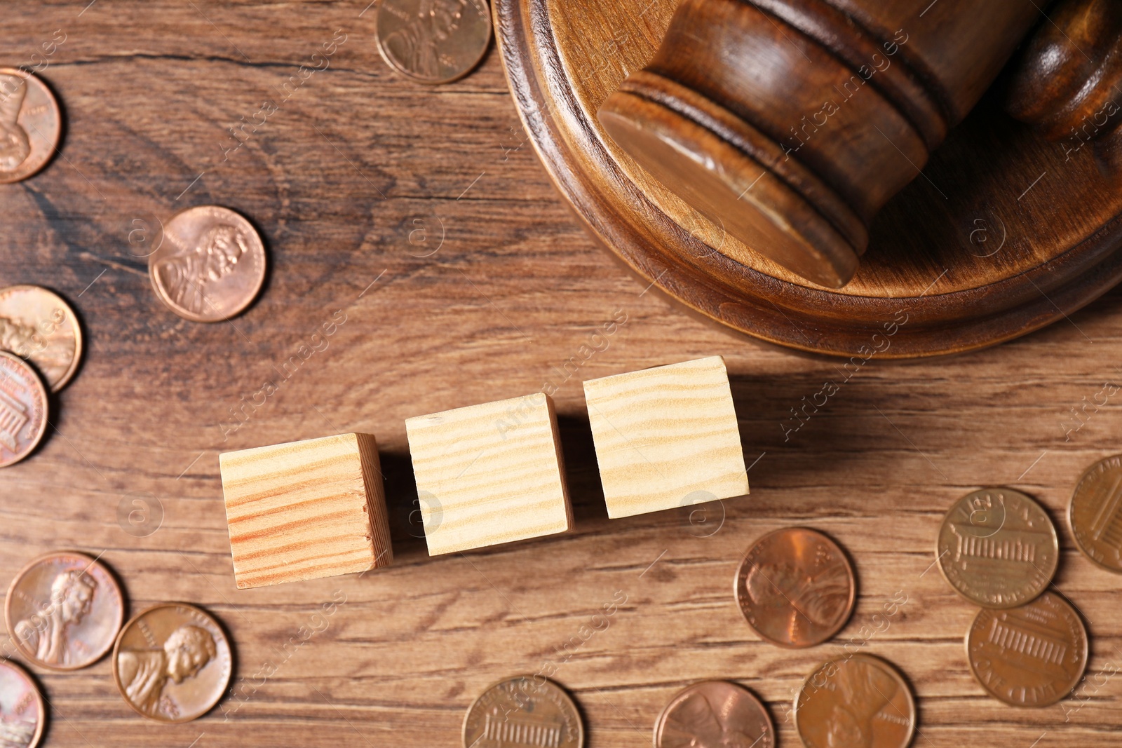 Photo of Tax law. Blank wooden cubes, coins and gavel on table, flat lay