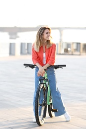 Young woman on modern bicycle in city