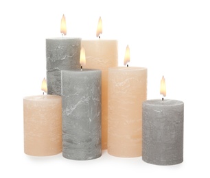 Photo of Many alight wax candles on white background