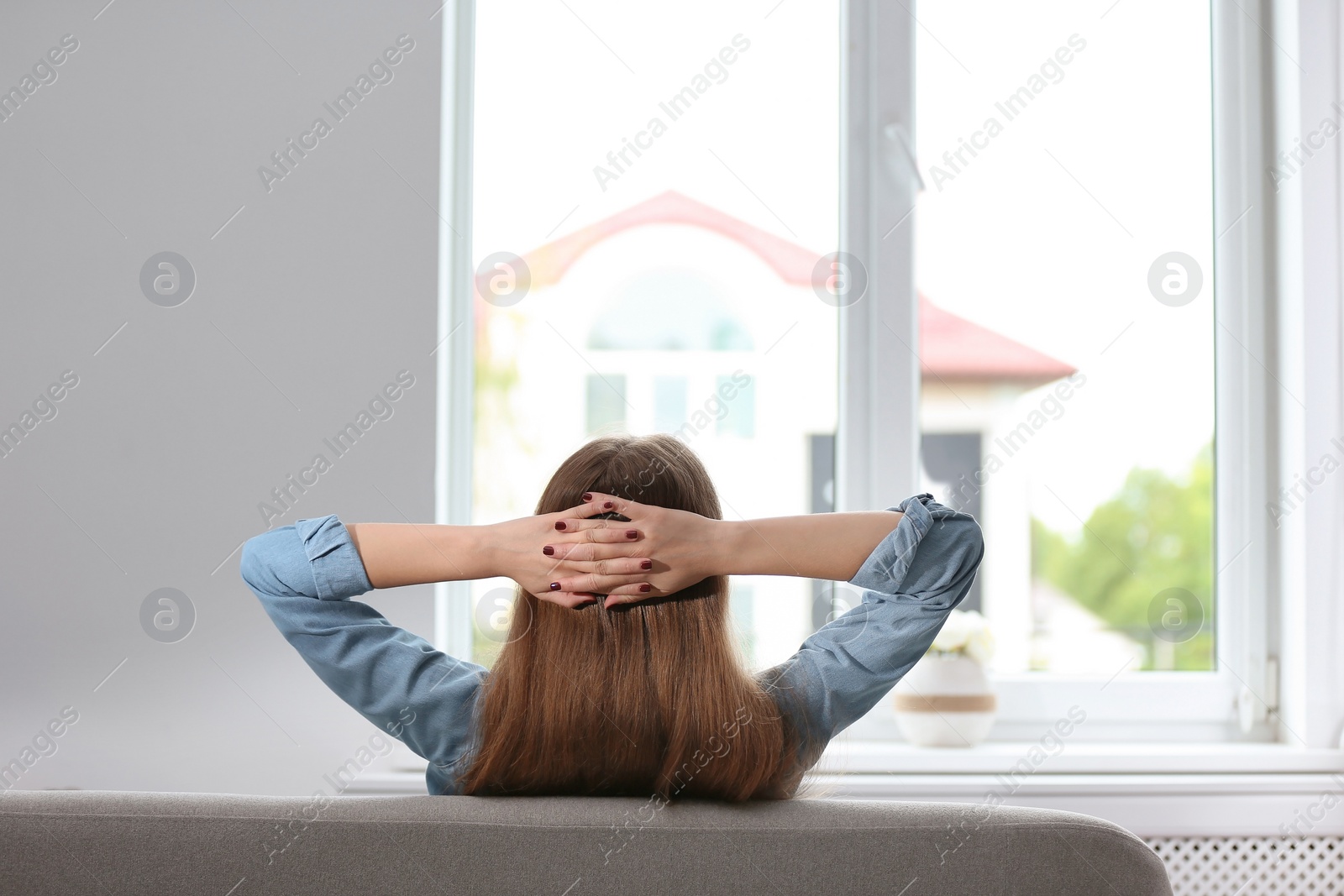 Photo of Young beautiful woman sitting near window at home